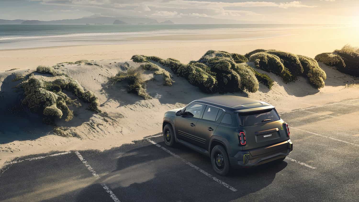 מבט אחורי מגבוה על רכב הקונספט רנו 4 Flower Power חונה לצד דיונת חול בחוף הים