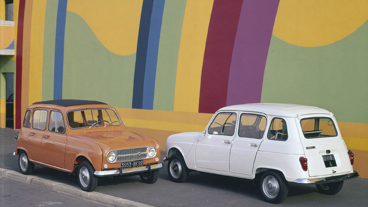 שתי מכוניות רנו 4L עומדות אחת מול השניה על רקע קיר צבעוני.