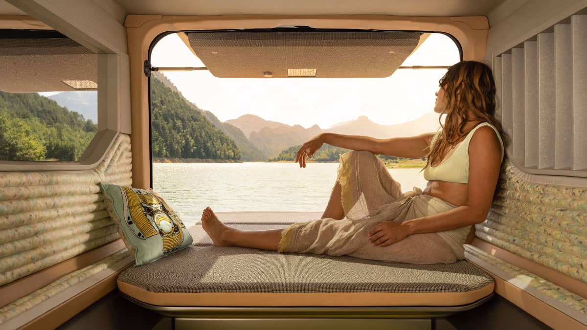 רכב קונספט Hippie Caviar Hotel' אשה יושבת על מיטה נשלפת החוצה ומביטה על הנוף