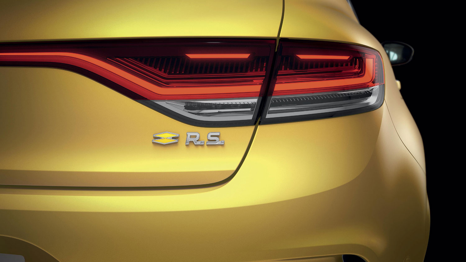 מכונית ספורט, רנו מגאן RS Trophy בצבע צהוב, מבט מקרוב על הפנס האחורי וסמל RS בפגוש.